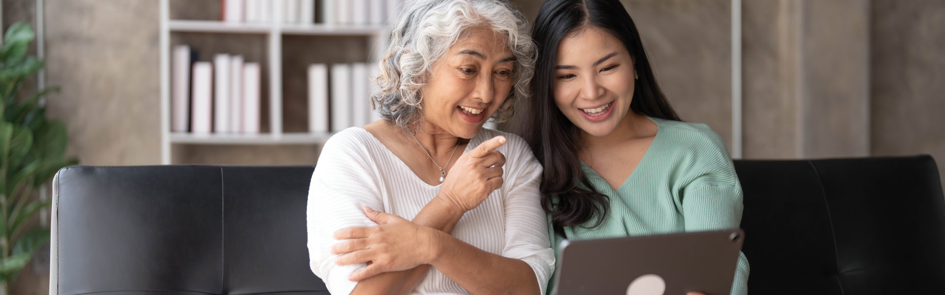 elderly and caregiver looking at a laptop